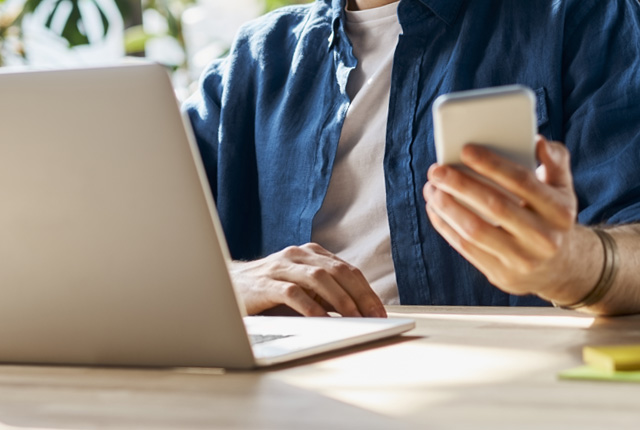 3) A man sitting at a desk with his laptop open 3) A man sitting at a desk with his laptop open